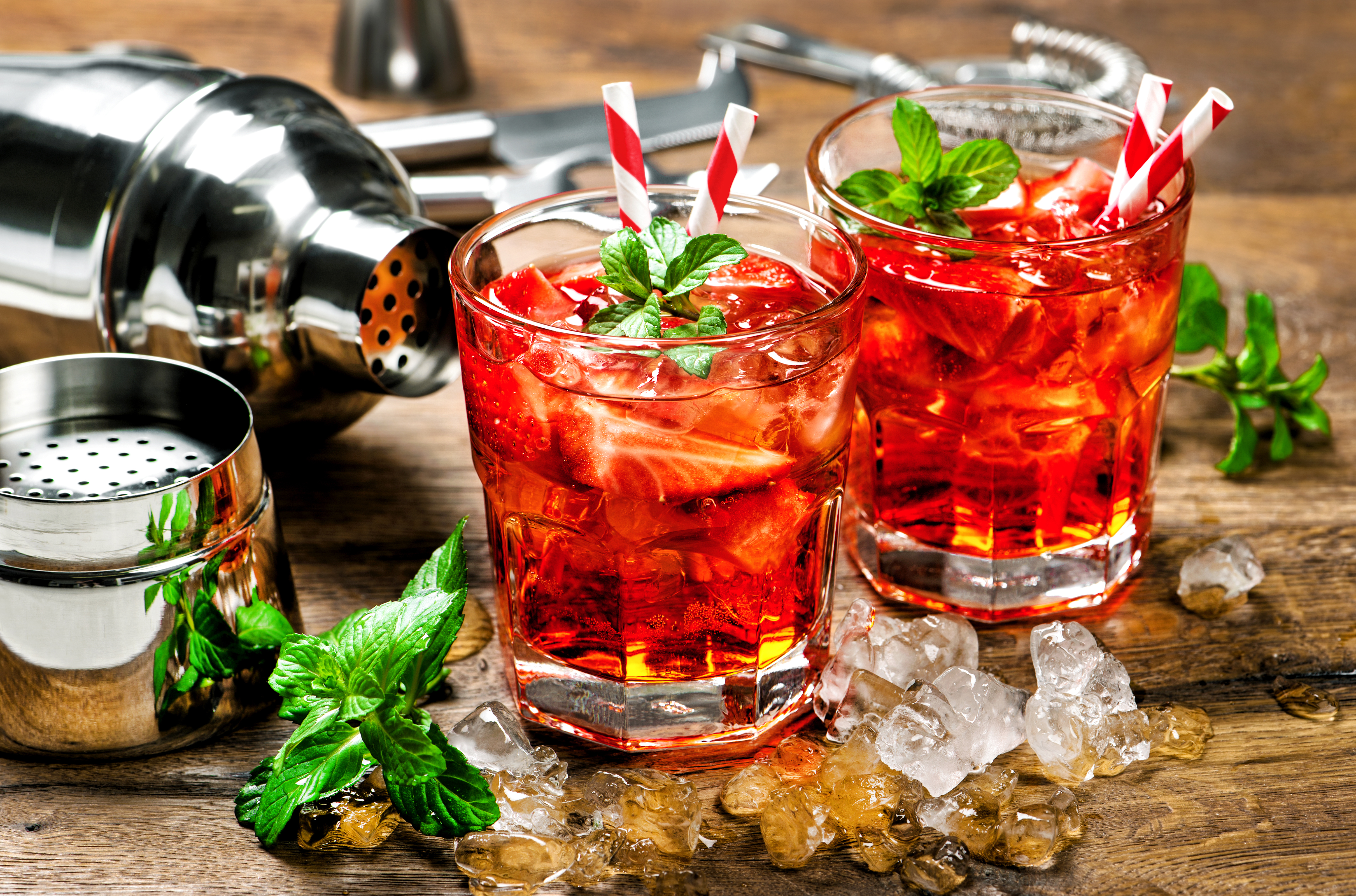 Red drink with strawberry, mint leaves, ice. Cocktail with campari, aperol, gin, liquor, juice, soda water
